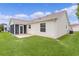 Well-maintained backyard with green lawn and view of the home's siding, window, screened in porch and attached patio at 1313 Arredondo Dr, The Villages, FL 32162