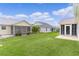 Expansive backyard featuring lush green grass and views of multiple properties with screened in porches at 1313 Arredondo Dr, The Villages, FL 32162