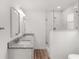Bathroom featuring dual sinks with granite counters and a glass-enclosed shower at 1313 Arredondo Dr, The Villages, FL 32162