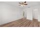 Bright bedroom featuring wood floors, a ceiling fan, and an ensuite doorway at 1313 Arredondo Dr, The Villages, FL 32162