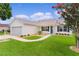 Charming single-Gathering home with a well-manicured lawn, lush landscaping, attached garage, and beautiful curb appeal at 1313 Arredondo Dr, The Villages, FL 32162