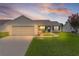 Charming single-story home with attached garage, walkway and manicured lawn against a colorful dusk sky at 1313 Arredondo Dr, The Villages, FL 32162