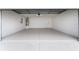 Spacious two-car garage with neutral painted walls and floors offers ample space for parking and storage at 1313 Arredondo Dr, The Villages, FL 32162