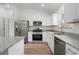 The updated kitchen boasts stainless steel appliances, granite countertops, and white cabinetry at 1313 Arredondo Dr, The Villages, FL 32162