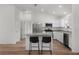 Modern kitchen with stainless steel appliances, granite countertops, white cabinetry, and island with seating at 1313 Arredondo Dr, The Villages, FL 32162