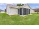 Exterior view of a screened-in porch and well maintained green lawn at 1313 Arredondo Dr, The Villages, FL 32162