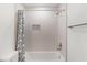 Tiled shower-tub combination in modern bathroom with recessed storage and curtain rod at 1313 Arredondo Dr, The Villages, FL 32162