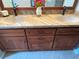 Close-up of a bathroom vanity with double sinks, granite countertop, and wood cabinets at 1512 Nueva Pl, The Villages, FL 32159