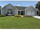 Charming single-story home with well-maintained lawn and colorful flower beds at 1512 Nueva Pl, The Villages, FL 32159