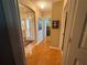 Inviting hallway with hardwood floors leads to a bright entryway and multiple rooms, creating a seamless flow throughout at 1512 Nueva Pl, The Villages, FL 32159