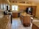 Well-equipped kitchen featuring granite countertops, an island, and modern appliances at 1512 Nueva Pl, The Villages, FL 32159
