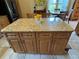 Close-up of kitchen island featuring granite counters and wood cabinets at 1512 Nueva Pl, The Villages, FL 32159