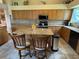 Traditional kitchen features wood cabinetry, island with granite counters and seating at 1512 Nueva Pl, The Villages, FL 32159
