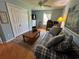 A blue-walled living room features a plaid couch, a decorative rug, a ceiling fan, and a closet at 1512 Nueva Pl, The Villages, FL 32159