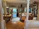 Open-concept living room and dining area with wood floors, decorative columns, and stylish furnishings at 1512 Nueva Pl, The Villages, FL 32159