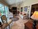 A cozy living room features a fireplace, tile flooring, a ceiling fan, and multiple seating options at 1512 Nueva Pl, The Villages, FL 32159