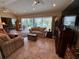 Bright living room with tile flooring, large windows, and comfortable seating at 1512 Nueva Pl, The Villages, FL 32159