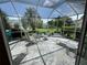 Relaxing screened patio with decorative concrete, seating and views of the landscaped yard at 1512 Nueva Pl, The Villages, FL 32159
