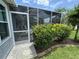 A cozy patio with screen enclosure and lush plantings adds a serene outdoor living space at 1512 Nueva Pl, The Villages, FL 32159