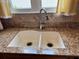 Close-up of a modern double-basin kitchen sink with granite countertop and backsplash at 1512 Nueva Pl, The Villages, FL 32159
