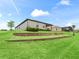 Beautifully landscaped backyard with a tiered retaining wall and green lawn at 17108 Se 111Th Terrace Rd, Summerfield, FL 34491