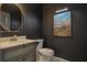 This bathroom features a round mirror and a painting above the toilet at 17108 Se 111Th Terrace Rd, Summerfield, FL 34491