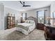 Comfortable carpeted bedroom with a ceiling fan, dresser, and a closet with built in shelving at 17108 Se 111Th Terrace Rd, Summerfield, FL 34491