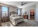 Bedroom with neutral walls, ceiling fan, large windows, carpet flooring, and walk-in closet at 17108 Se 111Th Terrace Rd, Summerfield, FL 34491