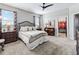 Comfortable carpeted bedroom with a ceiling fan, dresser, and a closet with built in shelving at 17108 Se 111Th Terrace Rd, Summerfield, FL 34491
