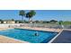 Community pool with in-water tanning deck, lounge chairs and umbrellas at 17108 Se 111Th Terrace Rd, Summerfield, FL 34491