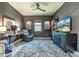 Comfortable den with gray walls, tile floor, ceiling fan, and view of the outdoors on TV at 17108 Se 111Th Terrace Rd, Summerfield, FL 34491