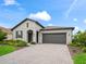 Single-story home with a two-car garage, a paver driveway, and mature landscaping at 17108 Se 111Th Terrace Rd, Summerfield, FL 34491