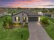 Beautiful single Gathering home with lovely landscaping, paver driveway and water view at sunset at 17108 Se 111Th Terrace Rd, Summerfield, FL 34491