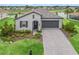 Attractive front exterior view with a brick driveway, manicured lawn, and modern facade at 17108 Se 111Th Terrace Rd, Summerfield, FL 34491