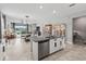 Bright, open kitchen with island seating, stainless steel dishwasher, and views into the inviting living spaces at 17108 Se 111Th Terrace Rd, Summerfield, FL 34491