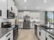 Modern kitchen boasts granite counters, stainless steel appliances, and ample white cabinetry with sleek, dark hardware at 17108 Se 111Th Terrace Rd, Summerfield, FL 34491