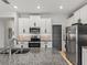 Well-equipped kitchen featuring stainless steel appliances, granite counters, and white cabinets, great for cooking and entertaining at 17108 Se 111Th Terrace Rd, Summerfield, FL 34491