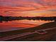 Stunning sunset view over the tranquil lake, reflecting vibrant colors in the water at 17108 Se 111Th Terrace Rd, Summerfield, FL 34491