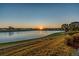 Serene lake view at sunset, reflecting the light on the water and surrounding the home at 17108 Se 111Th Terrace Rd, Summerfield, FL 34491
