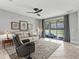 Bright living room with a ceiling fan, tile flooring, and sliding glass doors to a patio with lake views at 17108 Se 111Th Terrace Rd, Summerfield, FL 34491