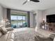 Bright living room with a ceiling fan, tile flooring, and sliding glass doors to a patio with lake views at 17108 Se 111Th Terrace Rd, Summerfield, FL 34491