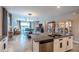 Open-concept living room and kitchen with granite countertops and view to the outdoor living at 17108 Se 111Th Terrace Rd, Summerfield, FL 34491