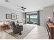 Bright living room with a ceiling fan, tile flooring, and sliding glass doors to a patio with lake views at 17108 Se 111Th Terrace Rd, Summerfield, FL 34491
