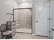 Tiled walk-in shower with glass door, bench, and a sleek design at 17108 Se 111Th Terrace Rd, Summerfield, FL 34491