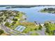 Aerial view of lakefront community with tennis courts and a lakeside playground at 17406 Chateau Pine Way, Clermont, FL 34711