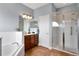 Well-lit bathroom with a walk-in shower and a separate soaking tub at 17406 Chateau Pine Way, Clermont, FL 34711