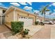 Townhome exterior with a two-car garage and lush landscaping showcasing the community's well-maintained grounds at 17406 Chateau Pine Way, Clermont, FL 34711