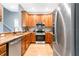 Well-equipped kitchen with stainless steel appliances, wooden cabinets, and granite countertops at 17406 Chateau Pine Way, Clermont, FL 34711