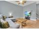 Comfortable living room with a gray sectional, ceiling fan, and a mounted TV screen at 17406 Chateau Pine Way, Clermont, FL 34711