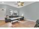 Cozy living room features tile floors, a plush gray sofa, and a bright window at 17406 Chateau Pine Way, Clermont, FL 34711